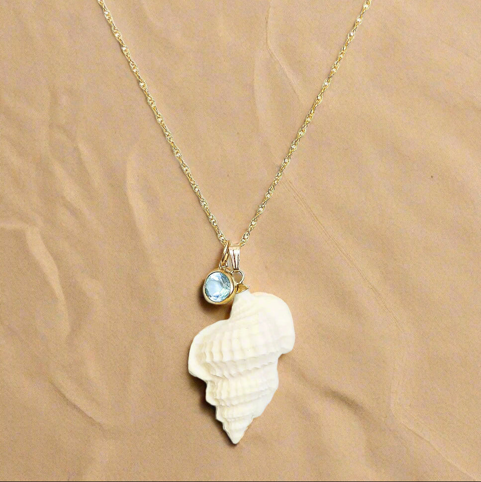 Necklace with a shell pendant and blue gemstone on a white background