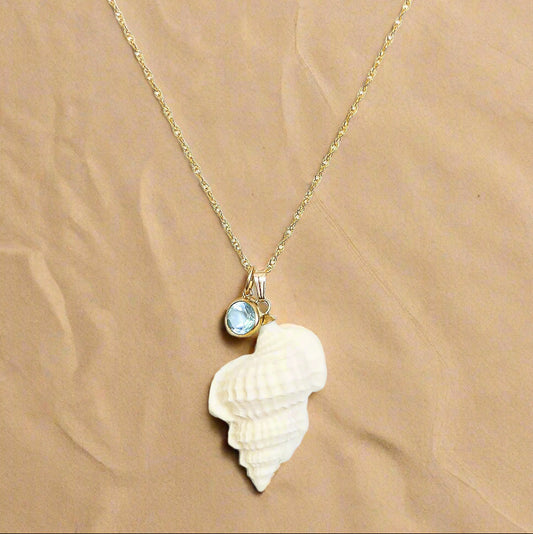 Necklace with a shell pendant and blue gemstone on a white background