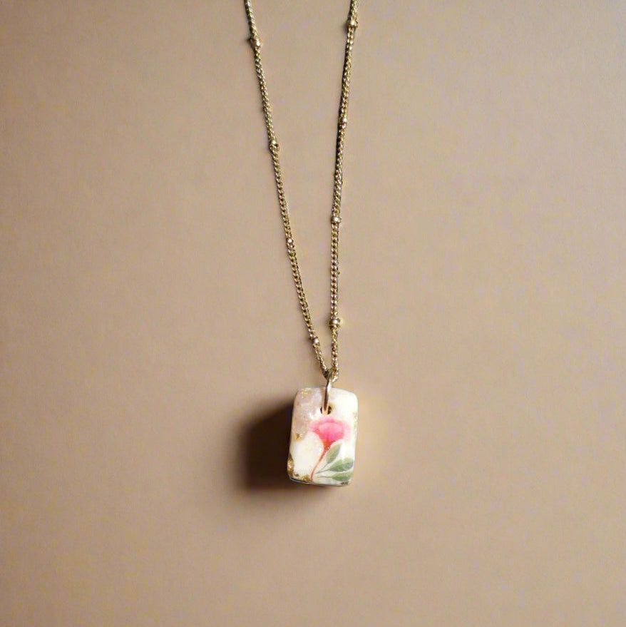 Necklace with a rectangular pendant on a textured surface